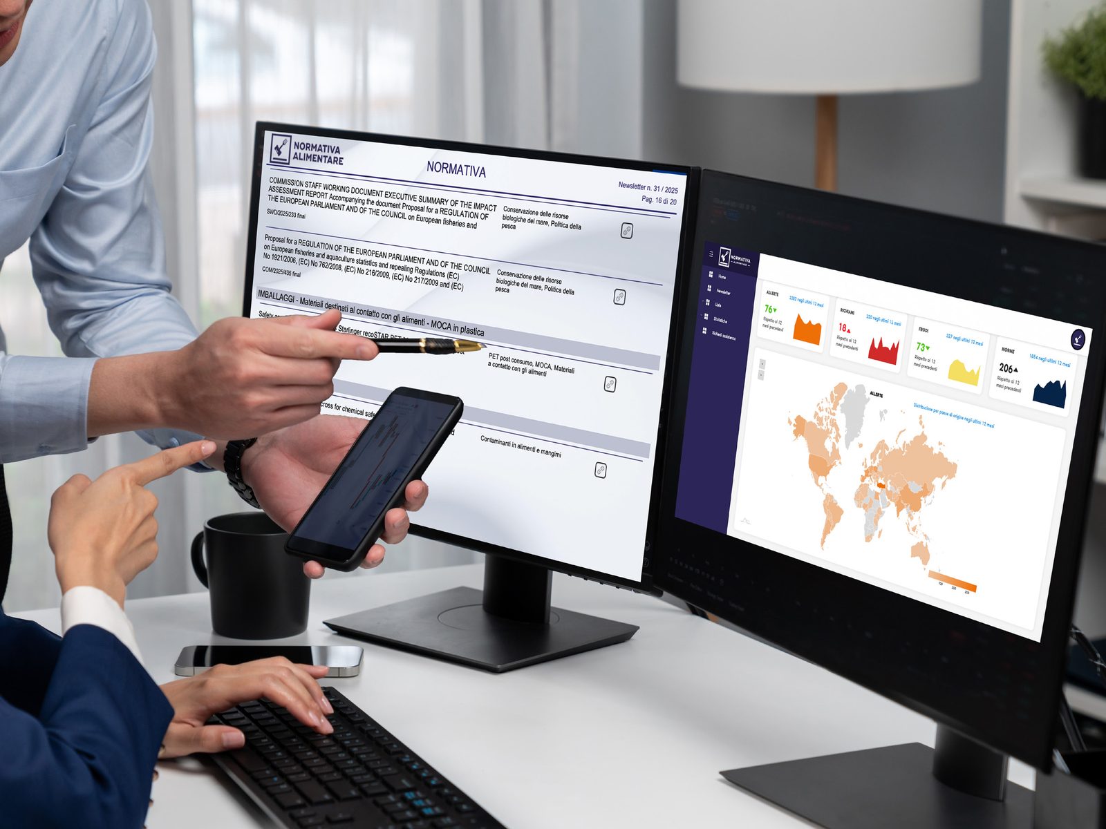 Due persone consultano su un monitor un software di aggiornamento normativo